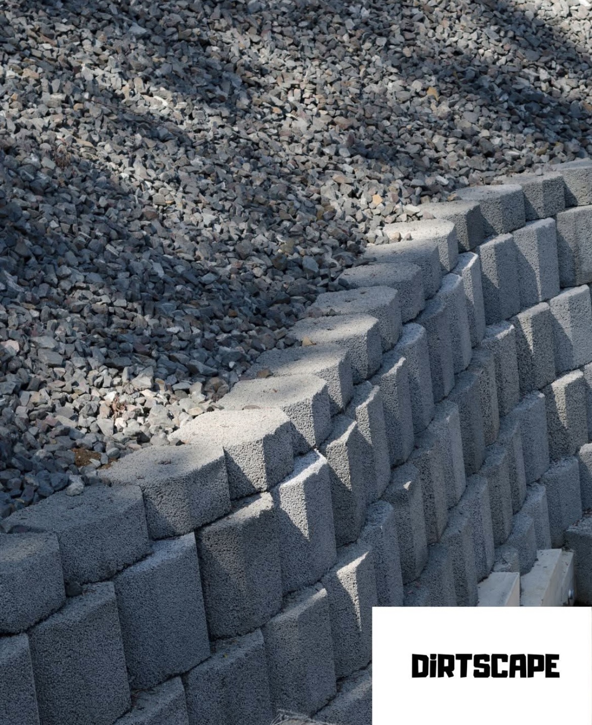 Segmental retaining wall with stepped blocks and gravel backfill